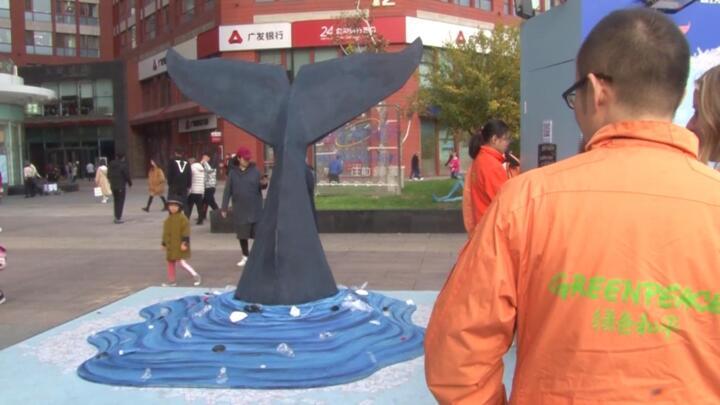 Greenpeace China representative looks at Singles' Day ocean plastic packaging display